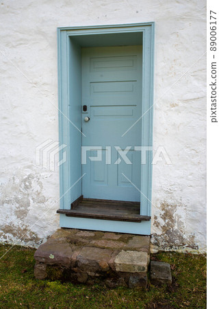Blue colonial wooden door in whitewashed stone cottage with rustic steps Blue colonial wooden door in whitewashed stone cottage with rustic steps 89006177
