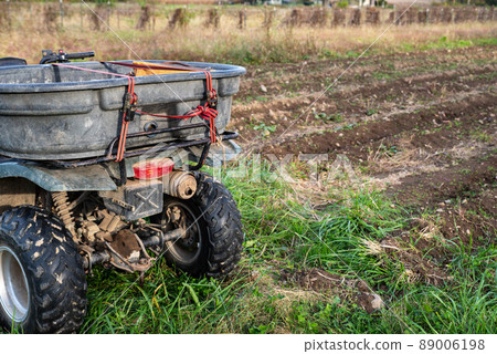 Closeup of hauling bin strapped to a farm ATV by a new garden 89006198
