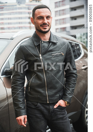 Portrait of smiling young man posing near his modern car outdoor. Portrait of smiling young man posing near his modern car outdoor. 89008865