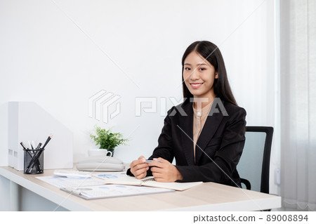 Asian businesswomen sit at their desks and calculate financial graphs showing results about their investments, plan a successful business growth process in the office 89008894