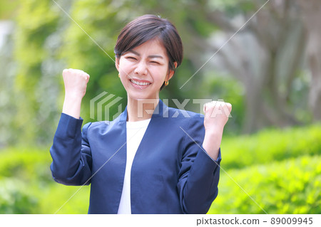 Woman in a navy jacket in a guts pose with both hands 2 Woman in a navy jacket in a guts pose with both hands 2 89009945