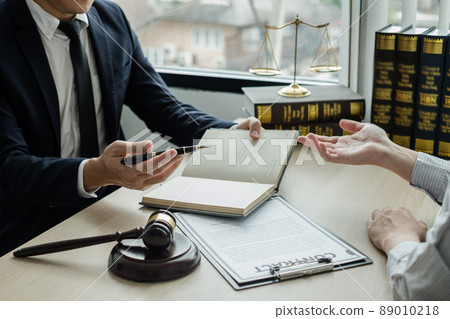 Male lawyers or a judge counseling clients about judicial justice and prosecution with scales, judges gavel, legal documents legal services concept 89010218