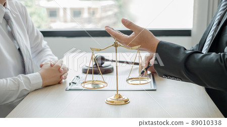 A man lawyer or a judge counseling clients about judicial justice and prosecution with scales, judges gavel, legal documents legal services concept 89010338