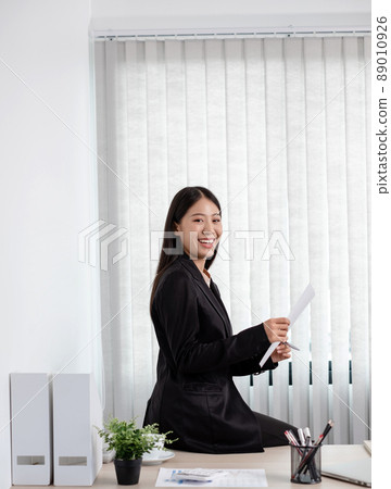 Asian businesswomen sit at their desks and calculate financial graphs showing results about their investments, plan a successful business growth process in the office Asian businesswomen sit at their desks and calculate financial graphs showing results about their investments, plan a successful business growth process in the office 89010926