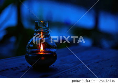 Lantern Lighting up the Dark on a Wooden Table and with a Dark Background, Warm Reflecting light Lantern Lighting up the Dark on a Wooden Table and with a Dark Background, Warm Reflecting light 89012140