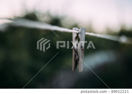 Old wooden clothespegs hanging on rope. 89012221