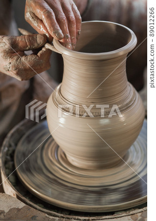 Potter working a piece of clay Potter working a piece of clay 89012266
