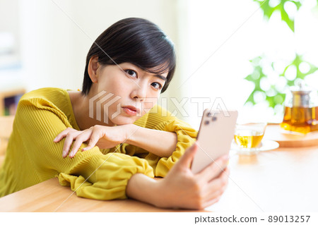Young women looking at smartphones Young women using smartphones in the room Lifestyle smartphones Smartphones 89013257