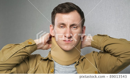 Man puts on bandage on neck to fix cervical vertebrae Man puts on bandage on neck to fix cervical vertebrae 89013543