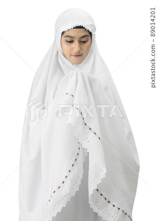 Asian Muslim woman in a veil standing while raised hands and praying 89014201