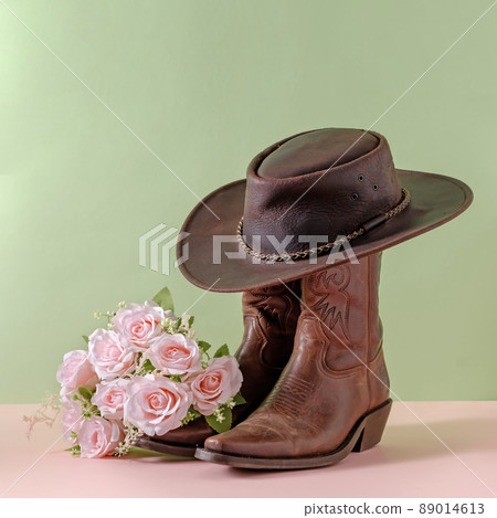 Cowboy boots shoes and hat and bouquet of rose flowers on green background 89014613