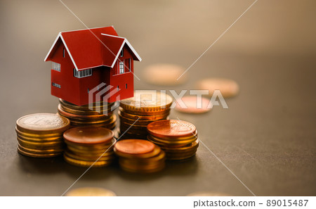 Mini house on stack of coins.The concept of real estate investments, loans, mortgages, taxes 89015487