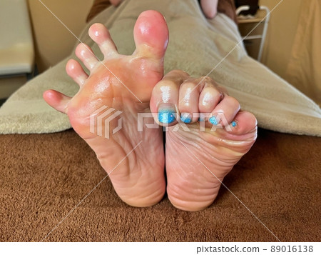 The sole of a woman who holds the left toe with the first joint and opens all the right toes. The sole of a woman who holds the left toe with the first joint and opens all the right toes. 89016138