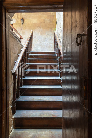 Open wooden door revealing wooden old staircase going up with with reflections of the stairs on the door Open wooden door revealing wooden old staircase going up with with reflections of the stairs on the door 89017217