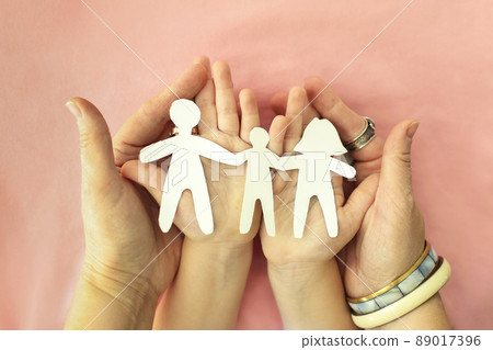 Parents and kid holding family paper cut out in hands. Celebrating International Day of Families 89017396