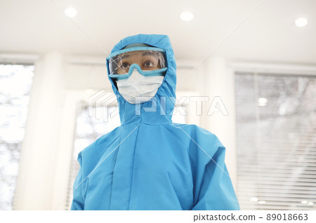 Portrait of young tired african american medical worker or nurse in protective gear and face mask 89018663