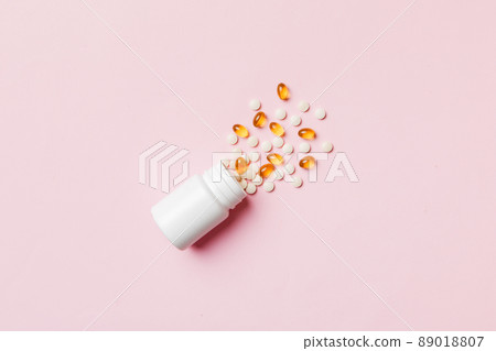 Multicolored pills and capsules in plastic bottle on Colored background, copy space. Many different various medicine tablets and pills, vitamin and nutritional supplements concept Multicolored pills and capsules in plastic bottle on Colored background, copy space. Many different various medicine tablets and pills, vitamin and nutritional supplements concept 89018807
