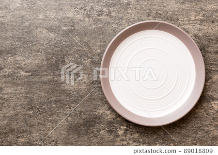 Top view of empty light plate on cement background. Empty space for your design Top view of empty light plate on cement background. Empty space for your design 89018809