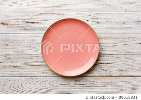 Top view of empty pink plate on wooden background. Empty space for your design Top view of empty pink plate on wooden background. Empty space for your design 89018831