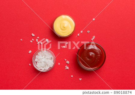 Bowl of salt, ketchup and cheese sauce on colored background, top view with copy space 89018874