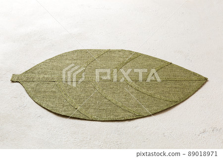 Perspective view of leaf shaped tablecloth for food on cement background. Empty space for your design. Perspective view of leaf shaped tablecloth for food on cement background. Empty space for your design. 89018971
