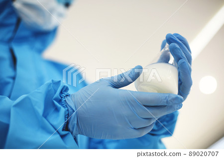 Female lab scientist examining samples in a test tube, working in an african american woman 89020707