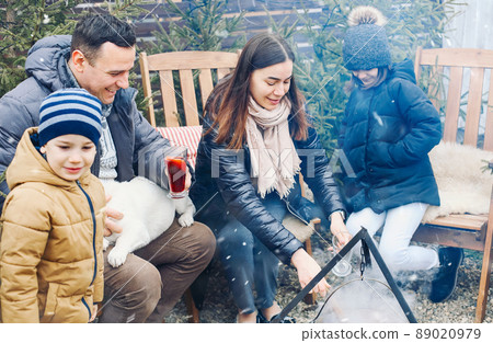 New Years gatherings by winter bonfire. Cozy portrait of happy family parents, New Years gatherings by winter bonfire. Cozy portrait of happy family parents, 89020979