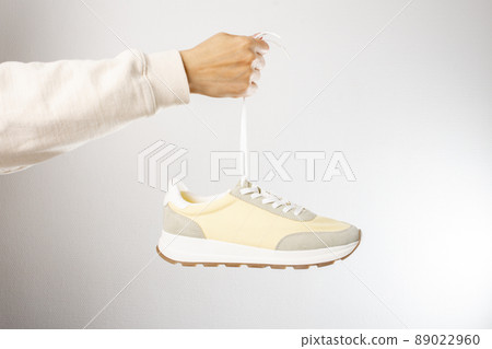 classic light color sneakers on grey background 89022960