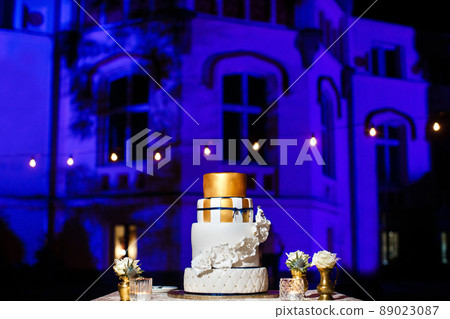 Multi level wedding cake with white flowers. 89023087