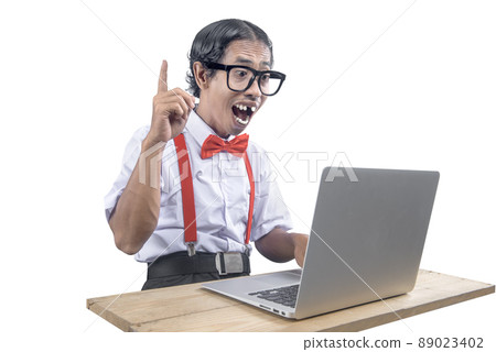 Asian nerd with an ugly face using laptop 89023402