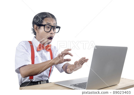 Asian nerd with an ugly face using laptop 89023403