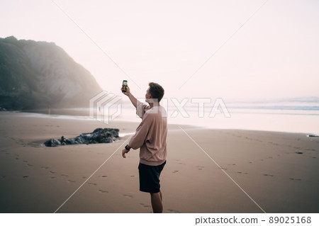 hipster guy generation z influencer shooting video about summer recreation on coast 89025168
