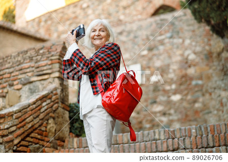 Cute elderly lady walking in day time outdoors Cute elderly lady walking in day time outdoors 89026706