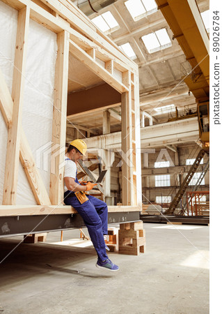 Male worker using notebook at house building construction site Male worker using notebook at house building construction site 89026784