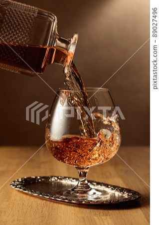 Brandy is poured into a snifter glass. 89027496