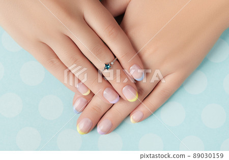 Beautiful womans hands with spring summer nail design on blue background Beautiful womans hands with spring summer nail design on blue background 89030159