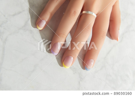 Beautiful womans hand with spring summer nail design on marble gray background 89030160