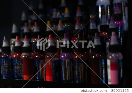 Bottles of multicoloured tattoo inks. Tattoo salon. Selective focus, blurred. Bottles of multicoloured tattoo inks. Tattoo salon. Selective focus, blurred. 89031365