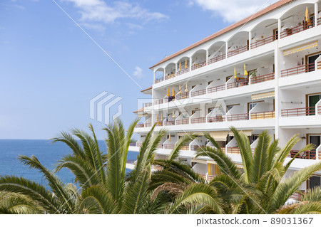 View to the apartments building near ocean with palm trees. View to the apartments building near ocean with palm trees. 89031367