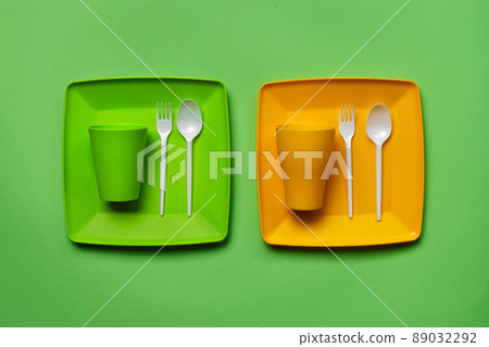 Colorful plastic disposable tableware on green background with copy space. The concept of picnic utensil. Top view. Selective focus. Close-up. Colorful plastic disposable tableware on green background with copy space. The concept of picnic utensil. Top view. Selective focus. Close-up. 89032292