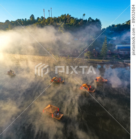 Aerial view of Sunrise with fog over Ban Rak thai, chinese village near a lake in Mae Hong Son Aerial view of Sunrise with fog over Ban Rak thai, chinese village near a lake in Mae Hong Son 89032684