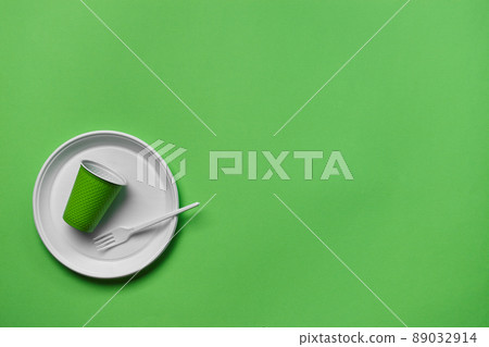 Colorful plastic disposable tableware on green background with copy space. The concept of picnic utensil. Top view. Selective focus. Close-up. Colorful plastic disposable tableware on green background with copy space. The concept of picnic utensil. Top view. Selective focus. Close-up. 89032914