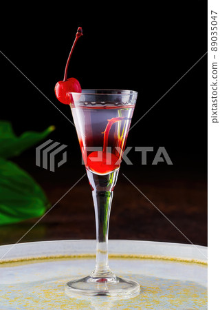 cherry liqueur and vodka cocktail with berry on wooden table. 89035047