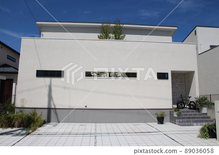 A beautiful and cool stylish mansion in the courtyard with a wall with continuous horizontal slits in the shape of a chalk cube that shines in the blue sky. A beautiful and cool stylish mansion in the courtyard with a wall with continuous horizontal slits in the shape of a chalk cube that shines in the blue sky. 89036058