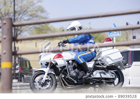 Police motorcycle accelerating at an intersection 89039528