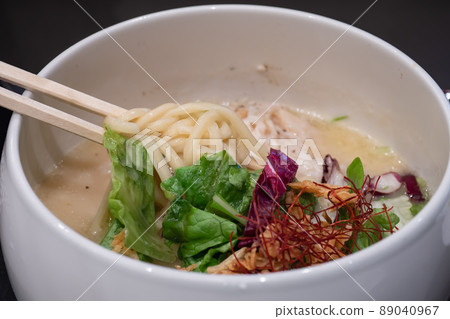 Chicken plain hot water ramen topped with vegetables such as lettuce. 89040967