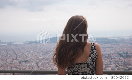 Girl staying on observation deck. Barcelona city aerial view. City overview. Girl staying on observation deck. Barcelona city aerial view. City overview. 89042652