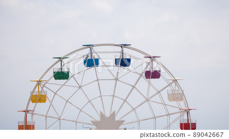 Ferris wheel on cloudy sky background. Rainbow 89042667