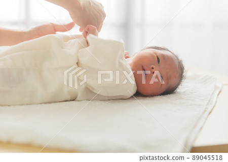 Newborn baby changing into underwear Newborn baby changing into underwear 89045518