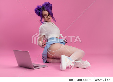 sex and a bright girl in summer clothes poses sexually showing underwear and stockings on the floor with a laptop 89047132